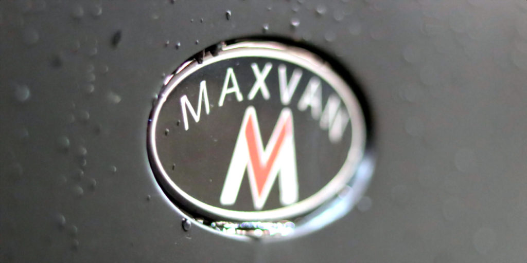 maxvan oval logo partially blurred with water drops